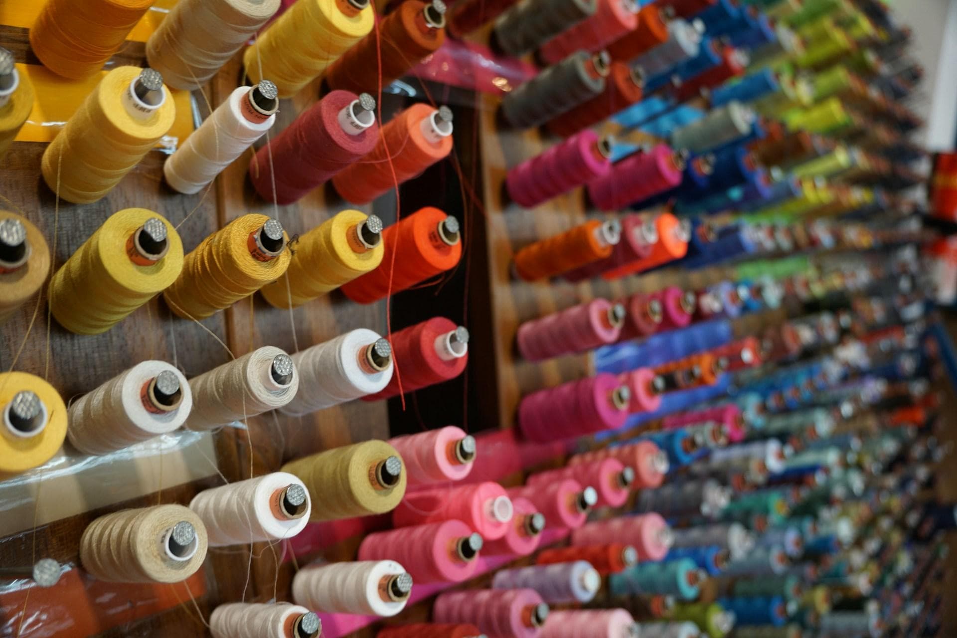 Wall of colorful thread spools in a professional sewing workroom